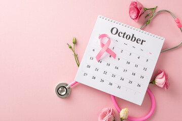 Make a difference this October in Breast Cancer Awareness Month. Top view of a calendar, stethoscope and pink ribbon on pastel pink isolated background, offering space for text or advertising