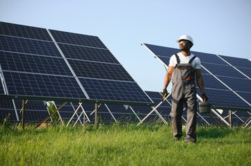 African American engineer maintaining solar cell panels. Technician working outdoor on ecological...
