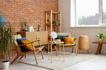 Interior of stylish living room with electric fan on coffee table