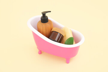Small bathtub with cosmetic products on color background