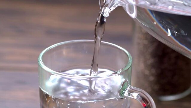 Pouring warm water into a glass. Preparation of chia seeds water