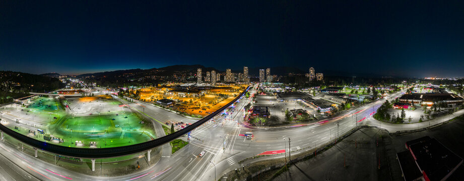 Aerial night-time panoramic photo view of Coquitlam Centre Mall, BC, Canada. Lougheed Highway and Barnet Highway intersection with Translink Coquitlam Skytrain station in view