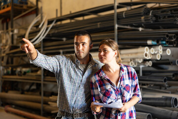 Warehouse manager indicates with his hand what to do to a hired worker