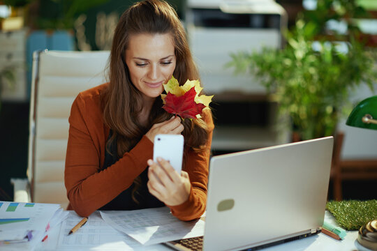 business owner woman in green office answering incoming call - Powered by Adobe