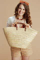 smiling elegant woman in blouse and shorts on beige
