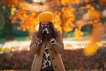 elegant woman in beige coat and orange hat - obrazy, fototapety, plakaty