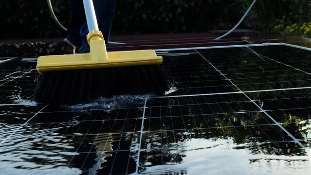 Man washing solar panels with water. fast motion .Solar Panel Efficiency.solar power technology.renewable energy.Alternative natural energy sources. 4k footage