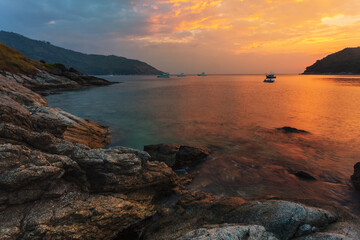 Fototapeta na wymiar Beautiful sunset on the rock beach.