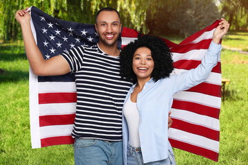 4th of July - Independence day of America. Happy couple with national flag of United States in park