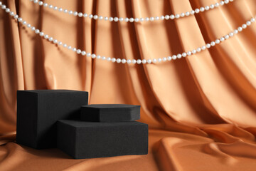 Black geometric figures and pearls on light brown fabric, space for text. Stylish presentation for...