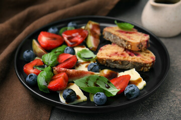 Delicious salad with brie cheese, berries and balsamic vinegar on brown table, closeup