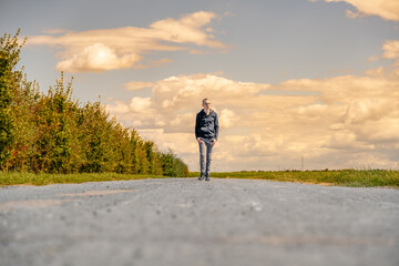 jeune homme marchant sur une route isolée seul