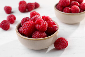 Tasty ripe raspberries on white table, closeup