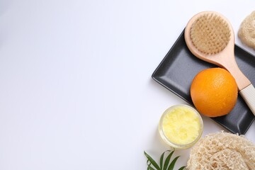 Orange, scrub and brush on white background, flat lay with space for text. Cellulite treatment
