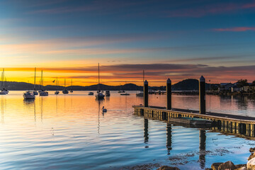 Obraz premium Beautiful sunrise with high cloud and boats on the water