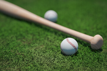 A background with a baseball and a baseball bat on the grass ground, 3d rendering