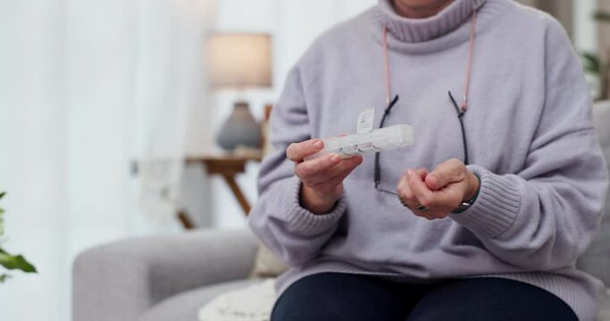 Senior woman, hands and pills on sofa for prescription medication, illness or healthcare at home. Elderly female person or patient taking tablets in container for mental health, cure or medicine
