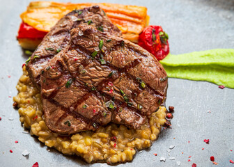 Grilled Beef Steak And Risotto. Beef steak with vegetables on a plate.