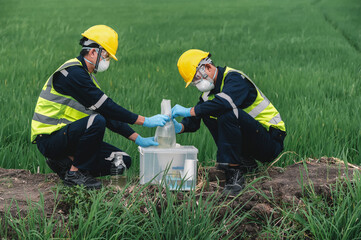 Two Environmental Engineers Take Water Samples at Natural Water Sources Near Farmland Maybe Contaminated by Toxic Waste or Suspicious Pollution Sites - obrazy, fototapety, plakaty