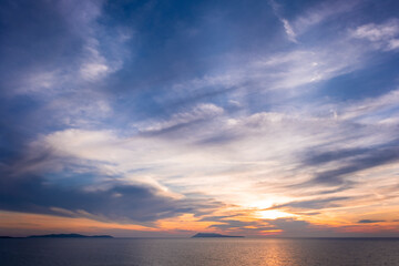 Sunset ovet sea and silhouette of islands in Greece. Summer time and mood. Beautiful vibrant evening. Corfu island.