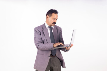 Indian businessman using laptop on white background.