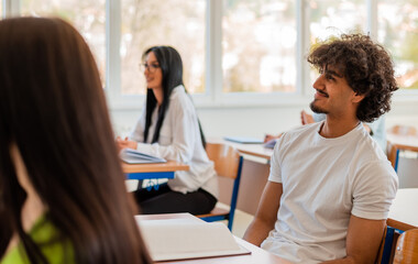Obraz premium In the classroom group of college students listening to a lecturer and writing in notebooks