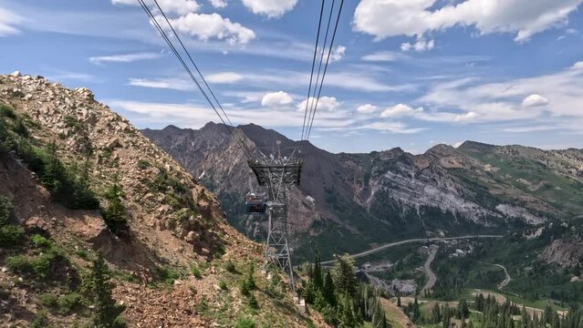 Summer ski tram snowbird mountain Utah descending. Summer and winter all season mountain resort. Vacation nature family fun destination. Recreation on rides, activities and events.