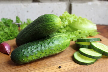 Fresh juicy cucumbers lie on a wooden cutting board.