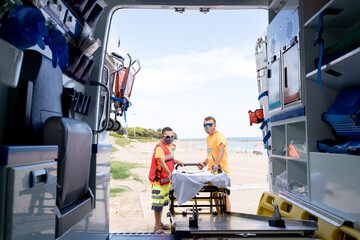 Lifeguards taking a stretcher out of an ambulance