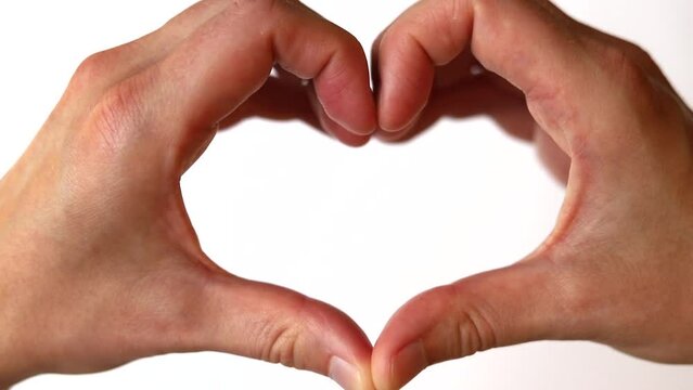 Pair of hands clasped together to make heart shape. White background.