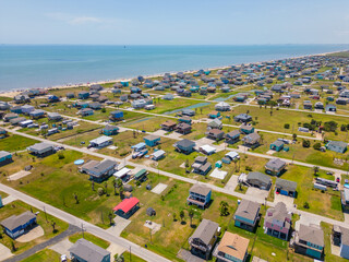 Aerial photo homes raised on stilts in flood zone Port Bolivar Texas