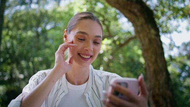 Girl talking video chat holding smartphone in forest closeup. Woman calling park