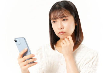 Fototapeta premium スマホを見て考えている女性