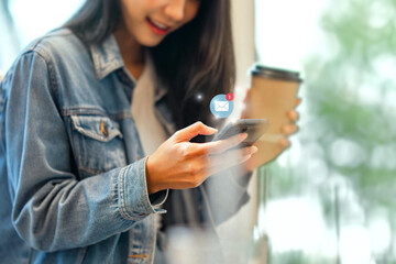 Fototapeta premium Woman hands using smartphone with 1 new email alert sign icon pop up, Female using phone for check email for work or sending text SMS short message while holding coffee cup at cafe.