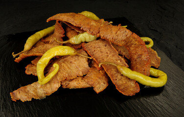Group of cooked doner kebab meat slices made from chicken and beef meat with green chilli peppers