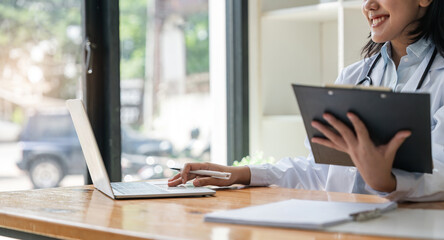 Female doctor working on laptop computer at office, Medical healthcare and doctor service concept