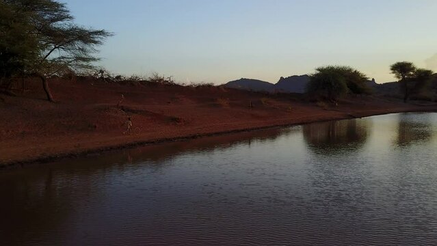 Aerial view of Borana child running along a water reservoir Oromia Ethiopia