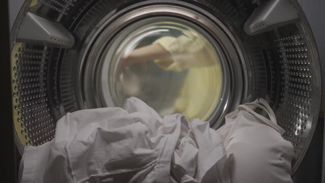 View from inside the washing machine, young couple having an argument while doing laundry HDR BT2020 HLG Material.