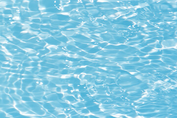 Blue water with ripples on the surface. Defocus blurred transparent blue colored clear calm water surface texture with splashes and bubbles. Water waves with shining pattern texture background.