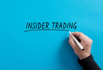 Male hand underlines the word insider trading on blue background. - obrazy, fototapety, plakaty