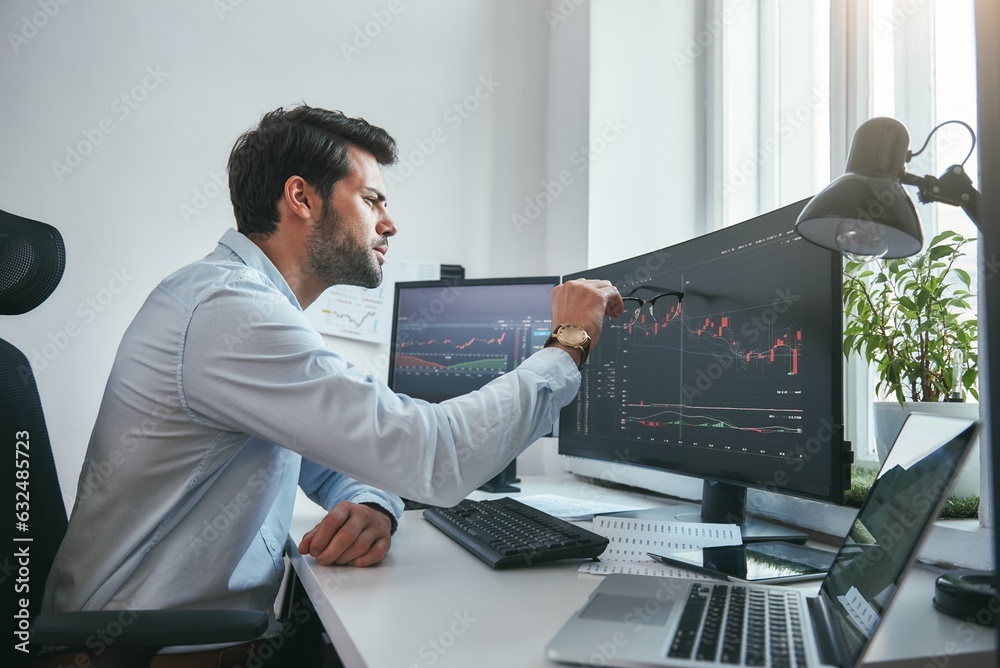 Fototapete analyzing data. thoughtful young trader is pointing at graphs on computer screen while working in hi