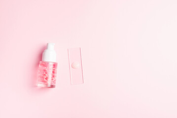 Liquid cosmetic product with pink molecules. Cosmetic laboratory concept. Product sample on laboratory glass
