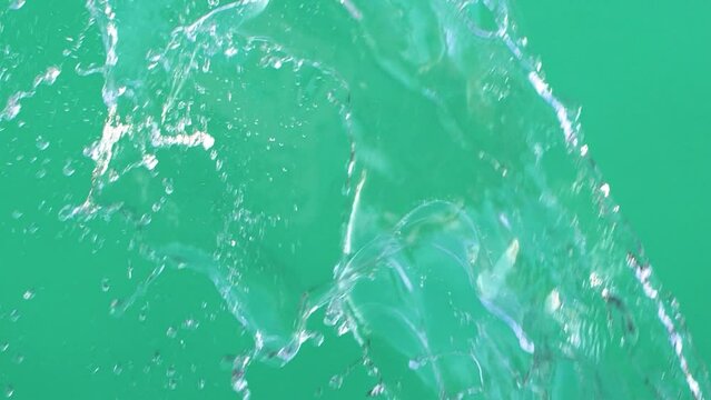 Slow motion of water splashing with drops on green screen chroma key background