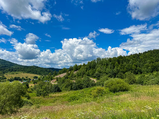 Awesome Carpathian mountains landscape background with forest and clouds on the summer season  