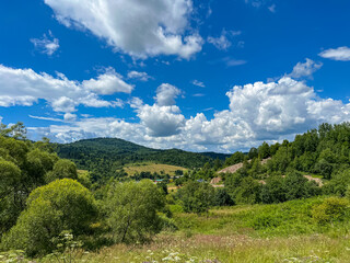 Awesome Carpathian mountains landscape background with forest and clouds on the summer season  