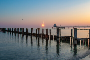 Obraz premium Zum Sonnenaufgang mit Sea Daughter, Spiegelfrau am Strand von Zingst an der Ostsee.