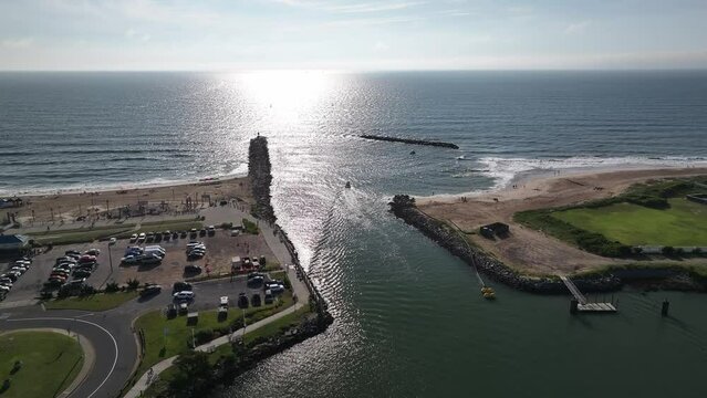Small boats heading out of Rudee inlet into the Atlantic Ocean into the sun