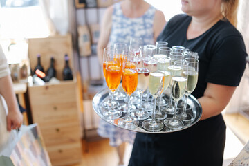 Alcoholic drinks and glasses on a silver tray at a wedding reception close-up