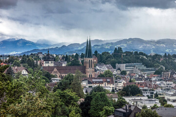 View at Bregenz and surrounding towns and mountains from mount Pfänder, a local mountain in austria at a rainy day in summer