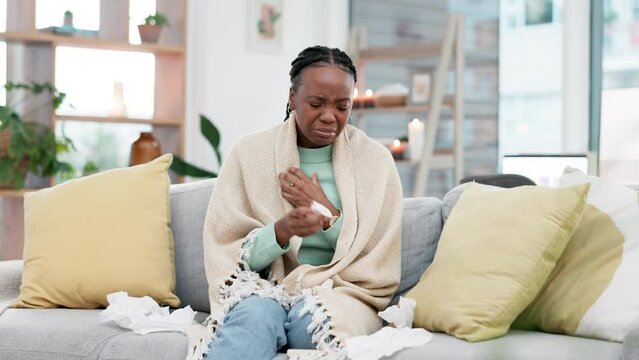 Sneeze, blowing nose and black woman on a sofa with tissue, flu or virus infection, influenza or bug in her home. Disease, bacteria and African lady sneezing with tuberculosis, pneumonia or allergies